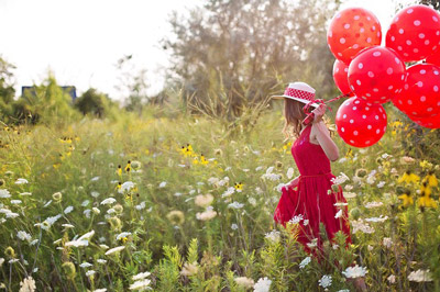 Young woman with red balloons