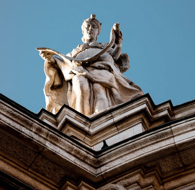 Statue high on corner of building